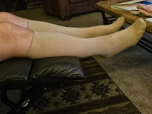 Customer's legs resting on a recliner wearing beige Eucalyptus Lyocell compression socks.