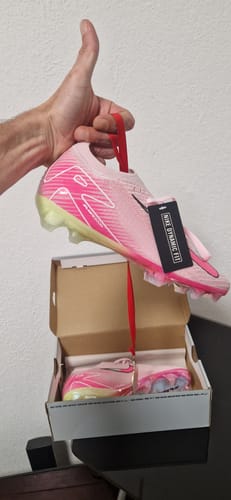 Customer's main Mercurial Vapor 16 By You shoe held by a hand above its box, displaying a bright pink design.