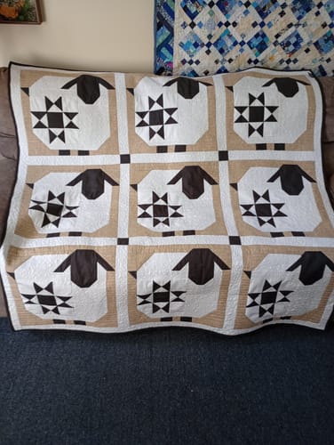 Customer's Wooly Stars sheep quilt finished with dark brown sheep blocks and a beige background.
