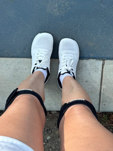 Customer's white CUURT Muuv court shoes with wide toe box, worn on a pickleball court