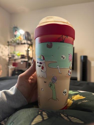Customer's Sunscream To-Go Buddy tumbler held in hand, featuring a beach-themed graphic with ghosts and skeletons.