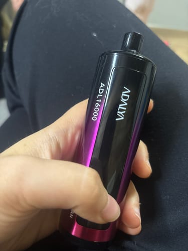 Customer's hand holding the Adalya ADL16000 disposable vape, featuring a sleek, purple and black design.