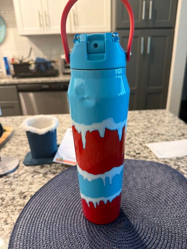 Customer's Bottle Buddy 32oz bottle with red and blue pattern, showing a small dent on the side, standing on a counter.