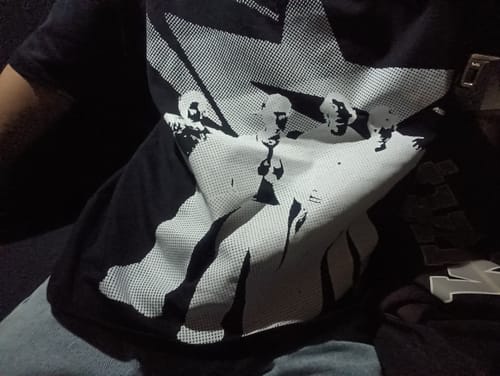 Customer's Radikal Merch siyah boxy tişörtün üzerindeki beyaz figür baskısının yakın çekimi.