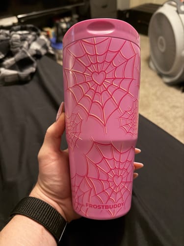 Customer's pink To-Go Buddy tumbler featuring a heart and spiderweb design held in a person's hand.