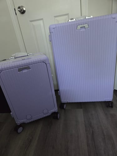 Customer's two light purple All-in-One Carry-On suitcases standing on a wood floor.