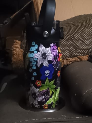 Customer's Bottle Buddy in Toxic Bloom print, standing in a cup holder with visible floral and ghost patterns.