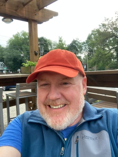 Customer's Big Dad Hat Washed in bright orange worn outdoors by a person with a beard.