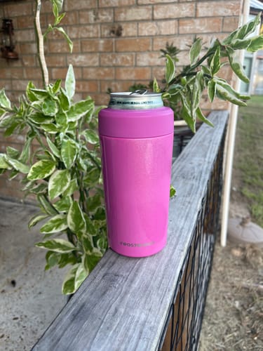 Customer's pink Universal Buddy can cooler holding a canned drink on a wooden railing outdoors.