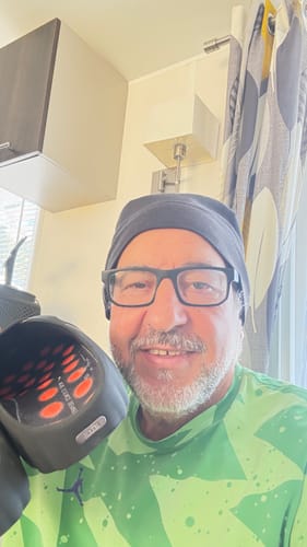 Reviewer smiling while holding a Nike Mind 001 sneaker, showing the interior cushioned sole design.