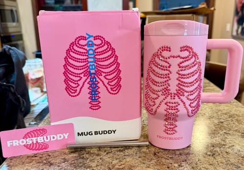 Customer's pink Mug Buddy and its packaging, featuring a skeleton rib cage design with sparkly rhinestones.
