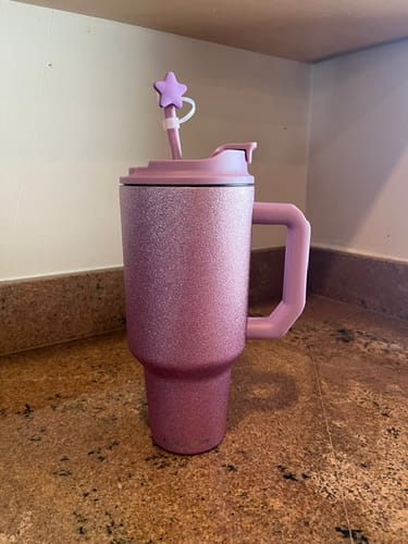 Customer's sparkly pink Thicc Buddy tumbler with a star-shaped straw topper on a granite countertop.