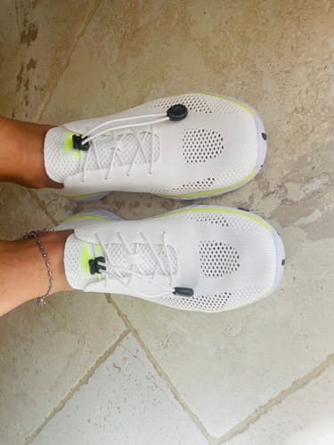 Reviewer's white Xdrain Pro Knit water shoes on feet, showing the breathable knit mesh and elastic lacing system.