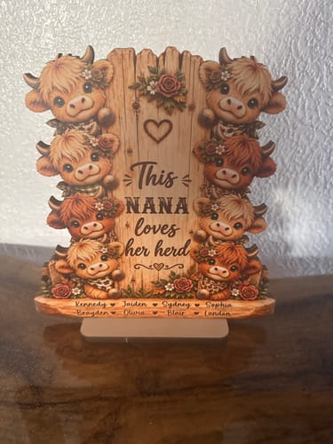 Customer's This Grandma Loves Her Herd wooden plaque, featuring illustrations of Highland cows and family names.