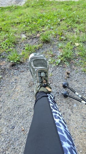 Reviewer's Active II Pro Barfußschuhe beim Wandern auf einem Schotterweg mit Wanderstöcken.