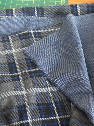 Customer's tartan effect wool fabric folded to show the plaid pattern and the solid blue reverse side.