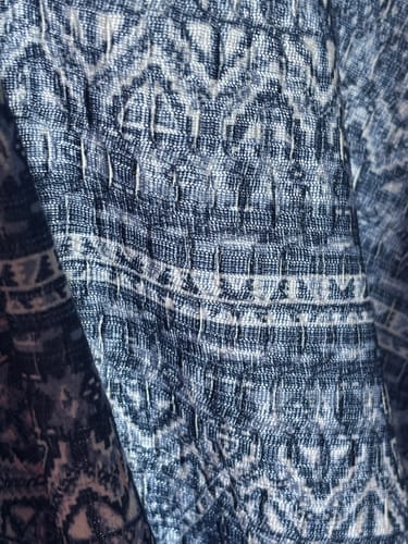 Reviewer's close-up of the blue textured scuba jersey fabric showing the detailed waffle pattern.