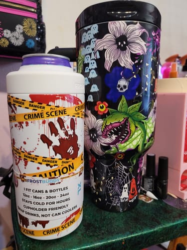 Customer's Frost Buddy shipping protection can cooler featuring a crime scene design, placed next to a spooky tumbler.