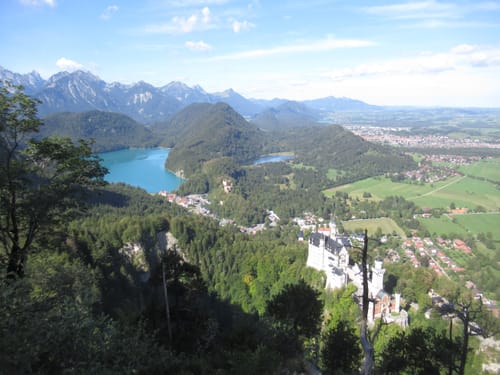 Reviewer's outdoor view of a landscape with a castle and a lake, suggesting the location of their Merino Shirt hike.