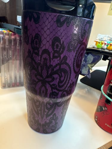 Customer's purple To-Go Buddy tumbler with a black lace pattern on a cluttered desk.
