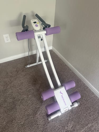 Customer's white and purple ab machine on carpet, featuring a single slider and a built-in LCD monitor.
