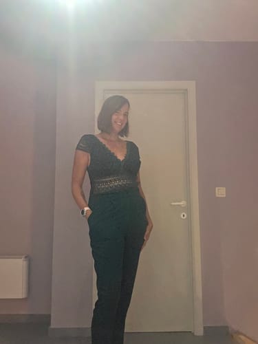 Reviewer's front view wearing the green CECILE jumpsuit with lace bodice and side pockets.