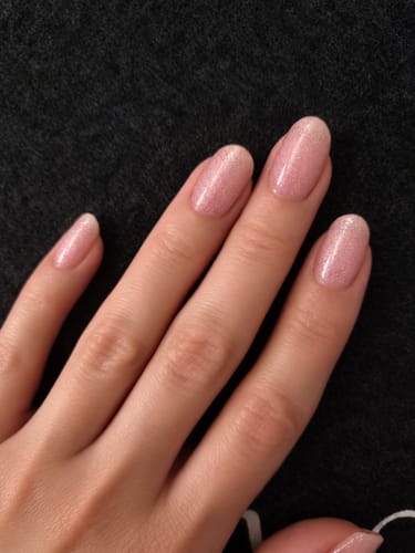 Customer's hand showing the Rosé CatEye UV Gel nail wraps with a shimmering, soft pink finish on oval-shaped nails.