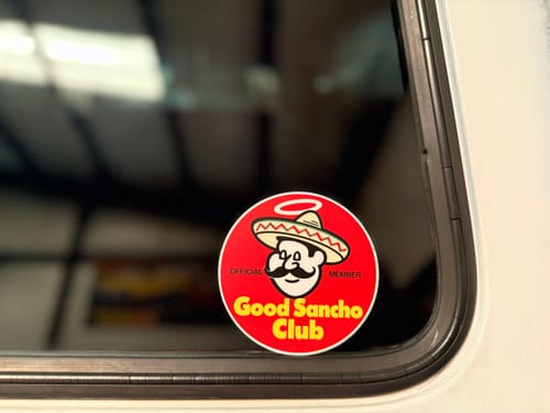 Customer's Custom Sample Sticker applied to a dark glass vehicle window.