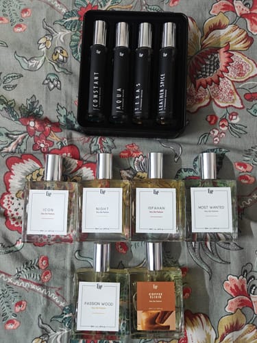 Customer's collection of Icon and various other em5 Eau De Parfum glass bottles and a travel set on a floral fabric.