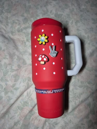 Customer's red FrostBuddy tumbler featuring three decorative Budz charms including a mushroom and a peace sign
