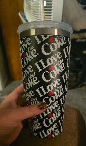 Customer's black To-Go Buddy tumbler with I Love Diet Coke print held in a person's hand.