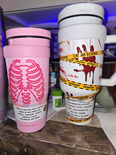 Reviewer's pink To-Go Buddy cup featuring a sparkling rhinestone skeleton rib cage design next to a crime scene mug.
