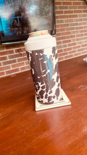 Reviewer's Cocoa Cow Universal XL can cooler on a wooden table holding a drink can.