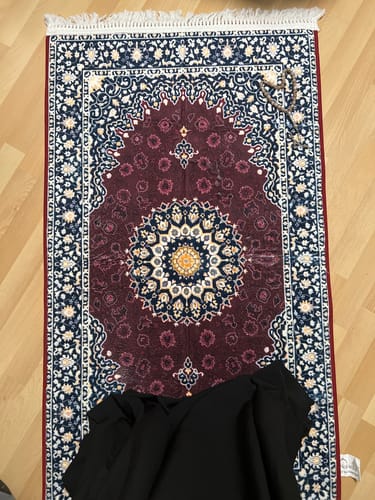 Customer's Moroccan Padded Prayer Mat in deep burgundy with intricate patterns, laid out with prayer beads.