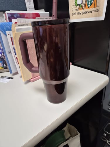Customer's Thicc Buddy 40oz mug in dark brown, sitting on a desk next to folders.