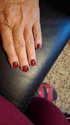 Reviewer's hand showing short nails with the ruby red Ruby CatEye UV Gel finish.