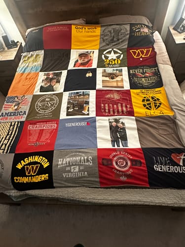 Customer's colorful Project Repat T-Shirt Quilt spread across a bed featuring various printed and photographic fabric squares.