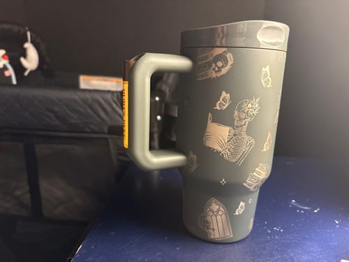 Customer's Mug Buddy 16oz in moonlit ink, featuring a skeleton and butterfly print and a built-in chapstick holder.