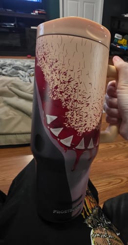 Customer's Thicc Buddy mug held in hand, showing a fleshy skin-tone graphic with hair and teeth patterns.