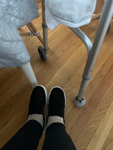 Reviewer wearing light-colored Eucalyptus Lyocell Compression Socks with black slip-on shoes near a walker.