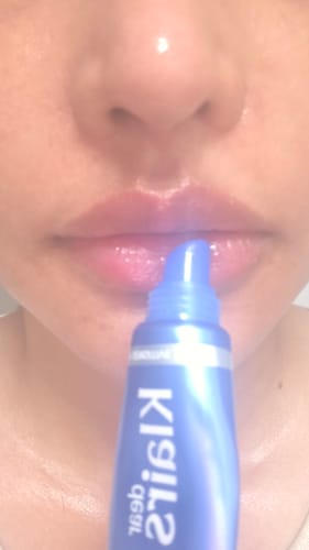 Customer's Blue EGF Intensive Pro Cream tube held in front of their mouth, showing the blue packaging.