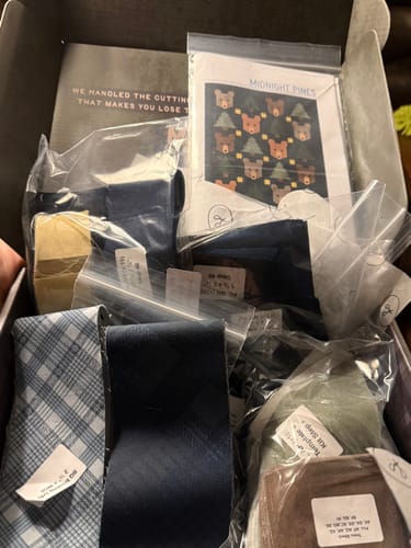 Customer's Midnight Pines Pre-Cut Quilt Kit with labeled fabric bundles and pattern in an open box.