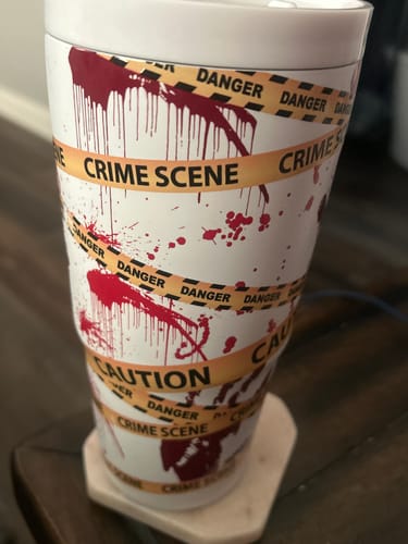 Reviewer's To-Go Buddy cup featuring a white surface with red blood splatters and caution tape patterns.