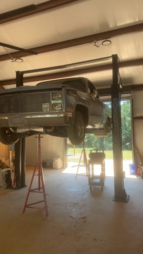 Reviewer's pickup truck lifted on a service garage rack, preparing for Fragola race hose fuel system installation.