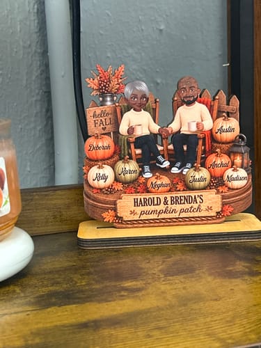 Customer's personalized wooden pumpkin patch plaque displayed on a wooden surface with a candle.