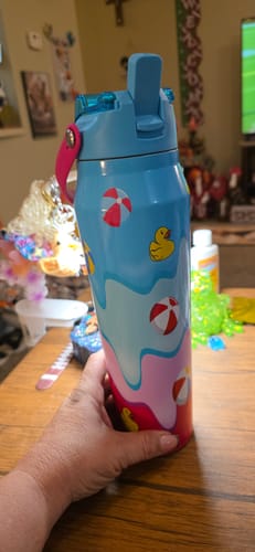 Customer's hand holding a blue Bottle Buddy with a colorful rubber duck and beach ball pattern.