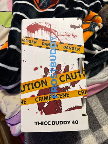 Customer's Thicc Buddy Gory themed packaging box with caution tape design on a patterned surface