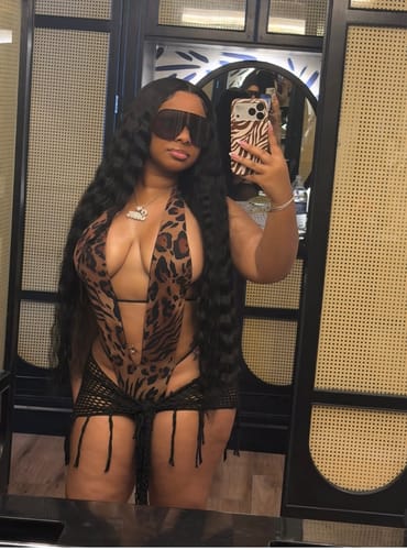 Customer's Zuri One Piece in animal print worn with a black mesh skirt in a mirror selfie.