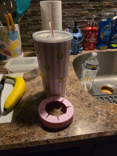 Customer's To-Go Buddy cup with softball pattern sitting on a kitchen counter next to a silicone base.