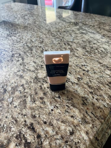 Customer's Foundation tube standing upright on a granite countertop, showing the product label.
